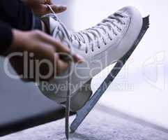Skates over stilletos anyday. an unrecognisable figure skater tying the laces on her ice skates.