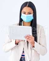 Browsing through live updates about the pandemic. Studio shot of a young woman wearing a mask and using a digital tablet against a white background.