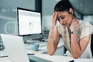 I think Ive messed my neck up again. an attractive young businesswoman sitting alone at her desk and feeling stressed.