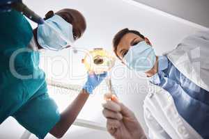 Lets give you a smile that matches your style. Low angle shot of two dentists getting ready to perform a procedure on a patient.