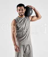 Be strong, positive and full of beast mode. Studio portrait of a muscular young man holding an exercise ball against a white background.