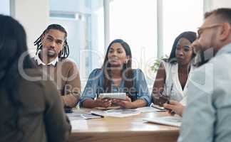 In order to understand, one must listen. a diverse group of businesspeople sitting together during a meeting in the office.