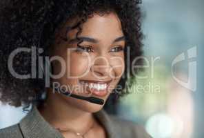 A smile is the best makeup a woman can wear. a young female agent smiling with her headset on while working in a call centre.