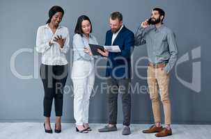 Working on individual and team productivity. a group of businesspeople working against a grey background.