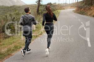 Final jog home. Full length shot of two unrecognizable athletes bonding together during a run outdoors.