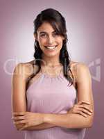 She leaves a little sparkle wherever she goes. a beautiful young cheerful woman with her arms folded against a pink background.