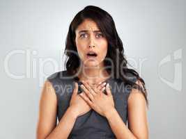 No one likes to hear bad news. a young woman looking surprised while posing against a white background.