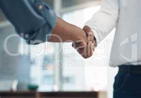 An agreement has been set in place. Closeup shot of two unrecognisable businesspeople shaking hands in an office.