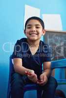 Guess what we learnt in school today. an adorable little boy completing a school assignment at his desk.