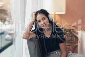 When life slows down, I turn the beat up. Portrait of a young woman using headphones at home.