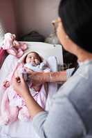 Life just got a whole lot cuter. a woman changing her baby girls clothing at home.