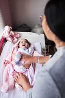 Diaper changing, less tears, more laughs. a woman changing her baby girls diaper at home.