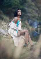 The way you dress expressed the amount of confidence you have. a fashionable young woman sitting against a rock outdoors.