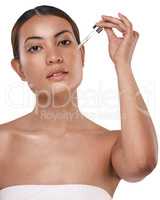 Whos ready for healthy looking skin. a beautiful young woman posing with a serum dropper against her face.
