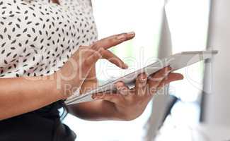 Improving workforce mobility with smart digital devices. Closeup shot of an unrecognisable businesswoman using a digital tablet in an office.