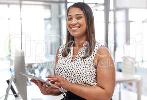 Tablets help reduce time and costs all around the office. Portrait of a young businesswoman using a digital tablet in an office.