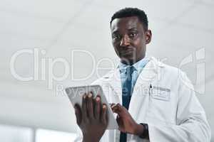 Youve got to stay current. Portrait of a mature doctor using a digital tablet in a hospital.