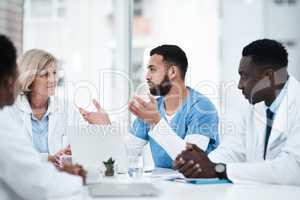 Devising an effective treatment plan together. a group of medical practitioners having a meeting in a hospital boardroom.