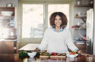 Health, wellness and food of a healthy lifestyle, portrait of happy black woman cooking in a kitchen. African American nutritionist making a healthy balanced meal with organic superfoods at home