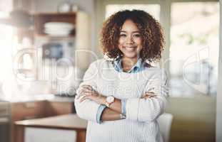Confident, happy and successful real estate agent standing with arms crossed after staging new property, house and home for sale. Portrait of smiling, proud or ambitious woman with afro ready to sell