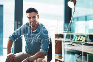 A confident, serious and powerful male entrepreneur sitting in a modern office or workplace. Portrait of a business man, leader or employer ready to be successful looking at the camera