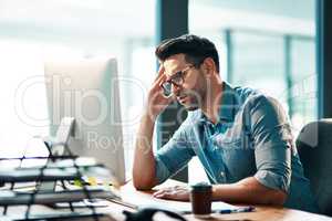 Stress, headache and frustrated business man working on computer in an office, annoyed and anxious. Male under pressure from a workload and deadline. Depressed guy experiencing burnout at work