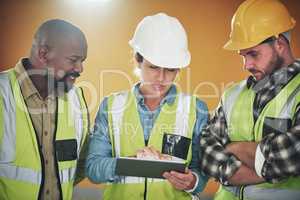 Construction projects gone paperless. a group of builders using a digital tablet while working at a construction site.