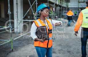 Time is the most important power tool on this site. a young woman checking the time while working at a construction site.