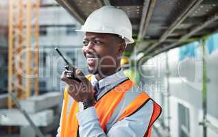 Communication carries a project from inception to completion. a young man using a walkie talkie while working at a construction site.