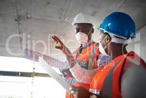 Construction that doesnt compromise on quality. a young man and woman going over building plans at a construction site.