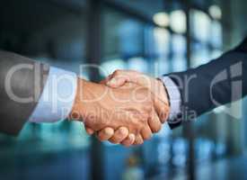 Handshake and teamwork with hands of two corporate and professional business colleagues or coworkers. An agreement, deal or partnership between merging companies to unite together and achieve success
