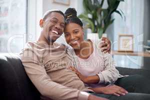 Its simple, its love. Portrait of a young couple relaxing on a sofa at home.