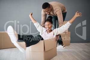 Filling their new home with tons of laughter. a young couple having fun while moving house.