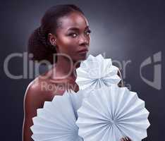 Theres nothing to lose in being bold. Studio portrait of a beautiful young woman posing with origami fans against a black background.