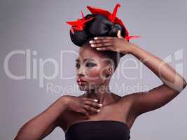 Makeup is my art - my face is the canvas. Studio shot of a beautiful young woman wearing Asian inspired makeup and posing with origami against a grey background.