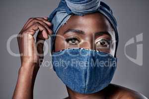 Theres no reason why you cant look your best in a mask. a beautiful young woman wearing a denim head wrap and mask.