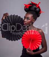 Its not about looking pretty - Id much rather be memorable. Studio portrait of a beautiful young woman wearing Asian inspired makeup and posing with origami against a grey background.