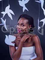 Youre a bright, beautiful goddess. Studio portrait of a beautiful young woman posing with paper birds against a black background.