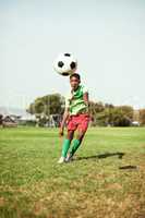 Shoot for your goals. a young boy playing soccer on a sports field.