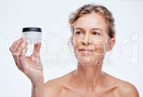 Theres only one product that works for me. a mature woman holding up a beauty product against a while background.