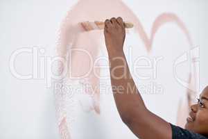 Art fill the world with heart. a young woman painting a heart on a wall.