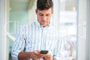 The best task manager for an entrepreneur on the move. a young businessman using a smartphone in a modern office.