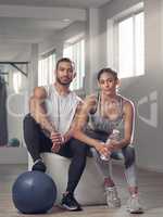 Were got 99 problems and laziness aint one. two young athletes sitting together at the gym.