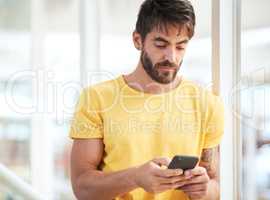 The gadget that gets it done fast and efficiently. a young businessman using a smartphone in a modern office.