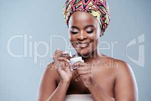Never forget to moisturize. Studio shot of a beautiful young woman posing with a jar of face lotion against a grey background.
