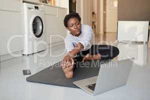 Self care is not an expense, its an investment. a young woman using a laptop while exercising at home.