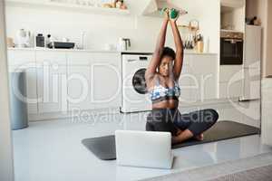 Its all about technique, power and endurance. a young woman using a laptop while exercising at home.