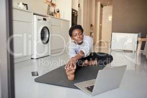 The internet is a great resource if you prefer exercising at home. a young woman using a laptop while exercising at home.