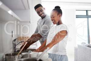 Dirty dishes dont stand a chance. a young couple washing the dishes together at home.