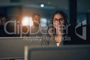 Customer service excellence is a critical competitive advantage for any business. Portrait of a call centre agent working in an office at night.